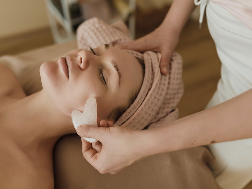 Frau bekommt eine Gua Sha Stein Anwendung