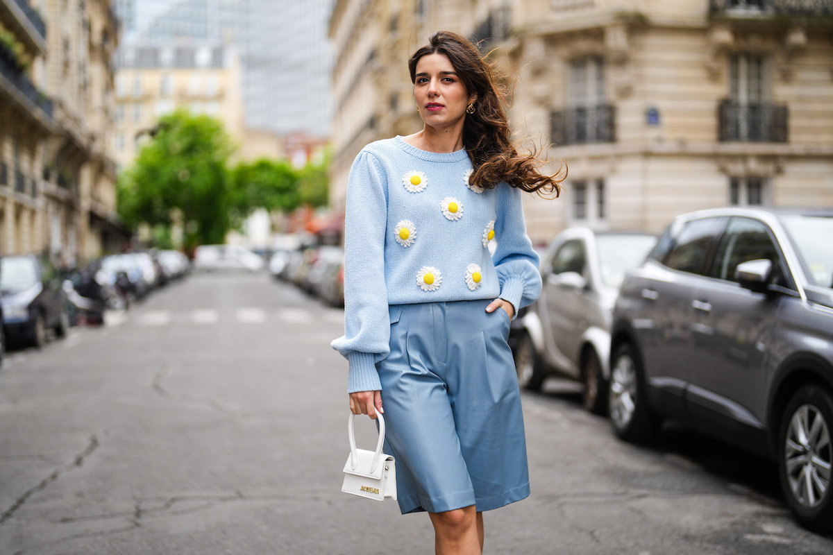 Frau trägt blaue Stoff-Bermuda-Shorts mit passendem Pullover