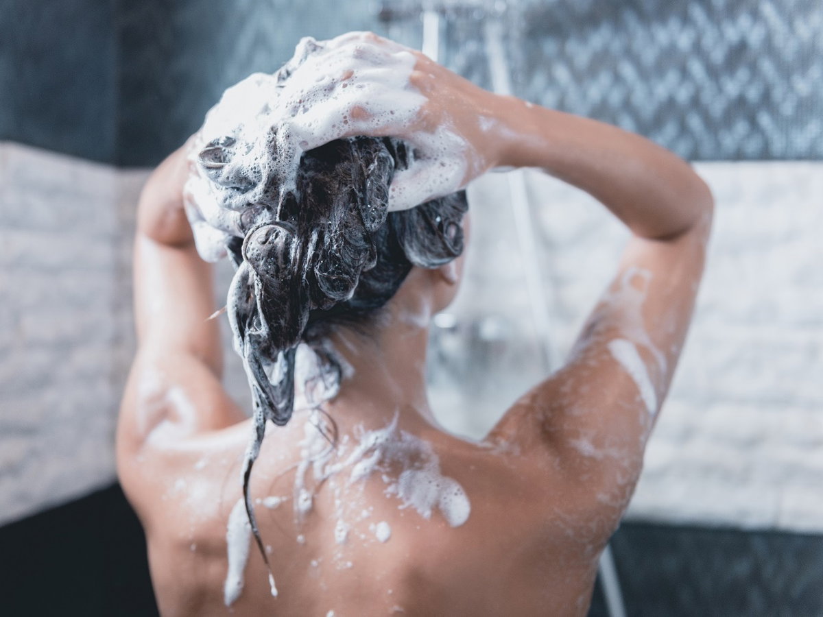 Frau wäscht sich Haare
