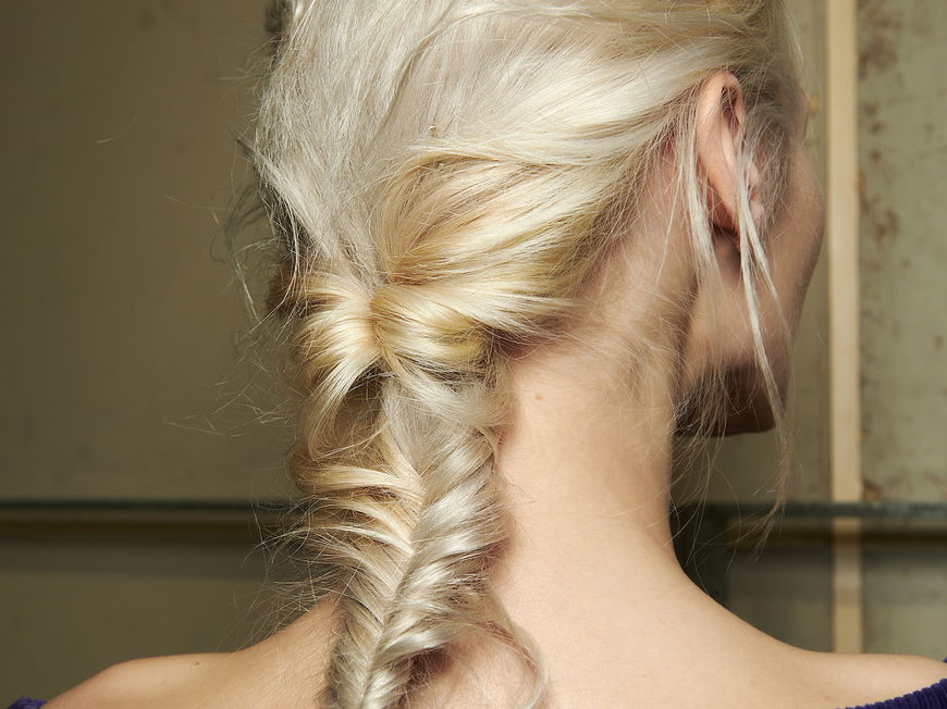 Frau mit blonden Haaren und Fischgrätenzopf