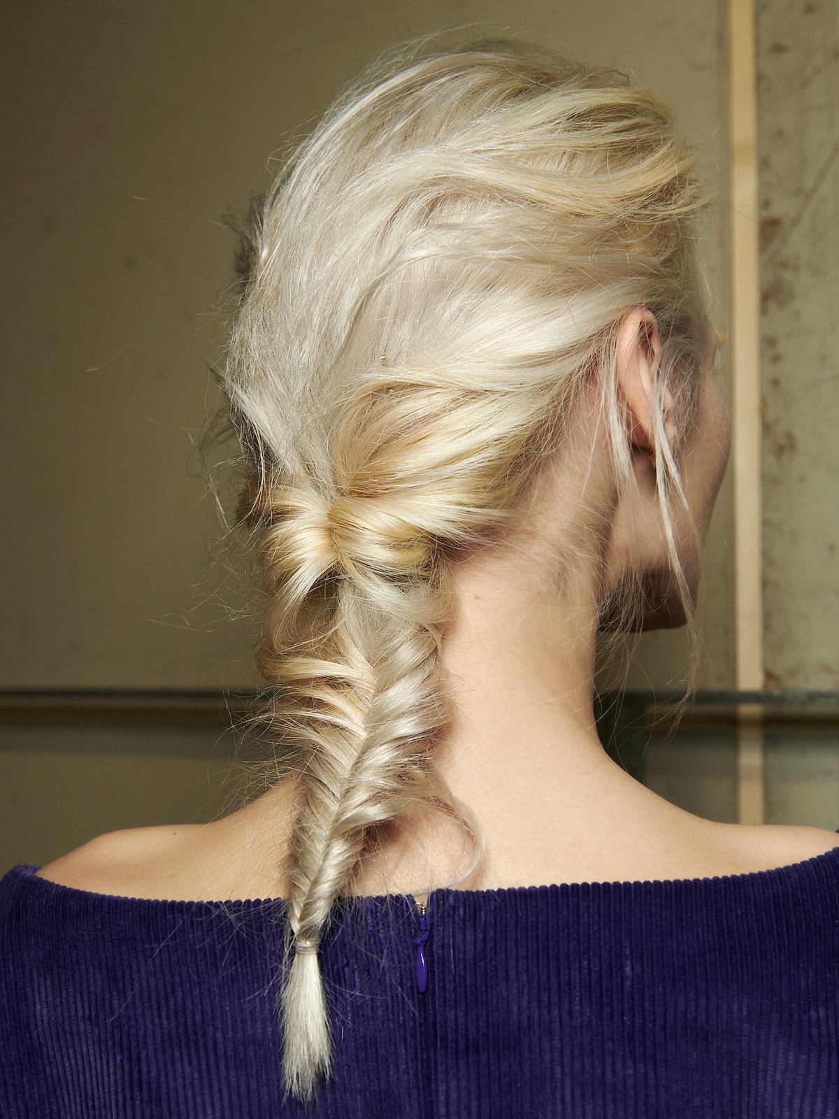 Frau mit blonden Haaren und Fischgrätenzopf