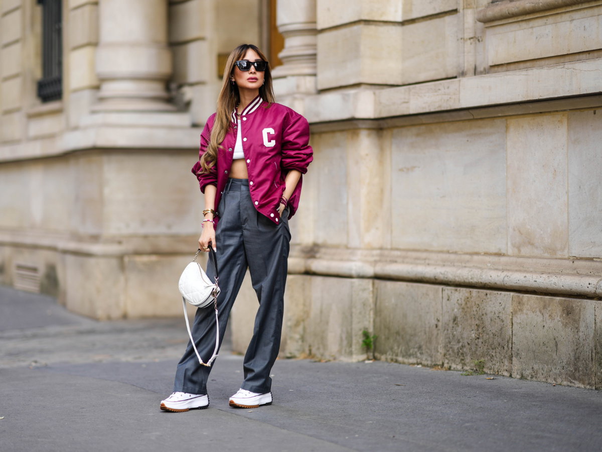 Frau trägt Converse Bomberjacke weite Hose Streetstyle
