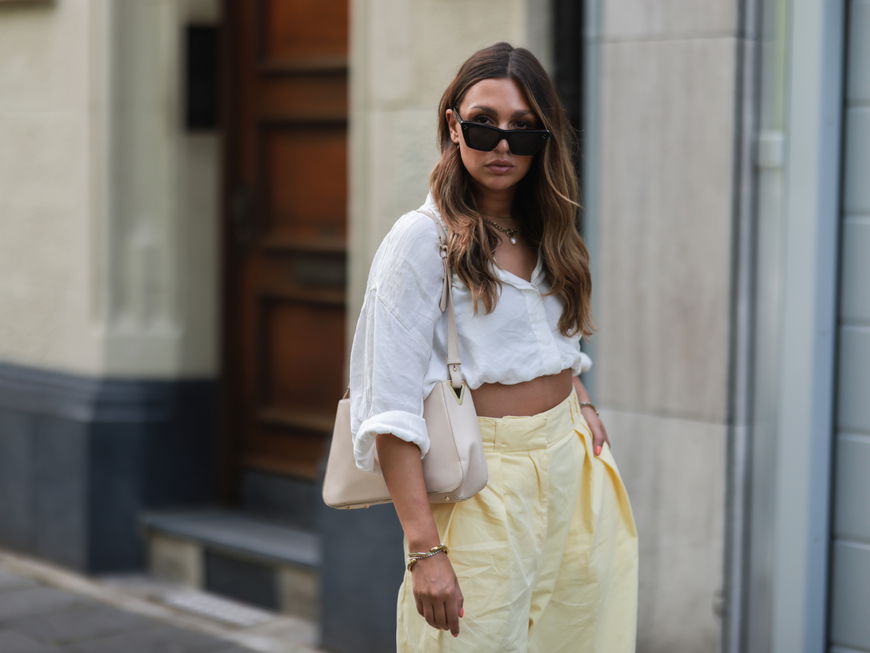 Kira Bejaoui trägt weiße Bluse Sonnenbrille beige Tasche Streetstyle