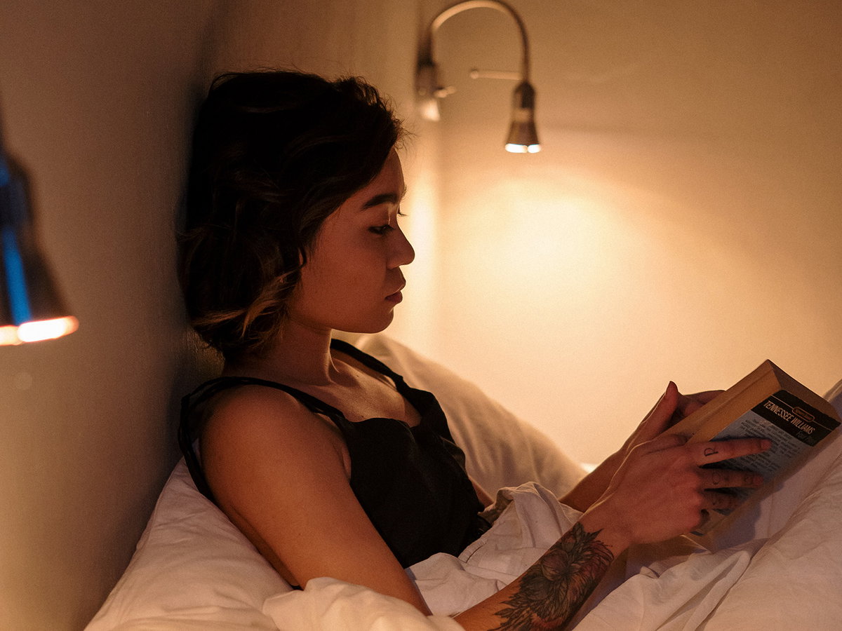 Frau liest Buch im Bett