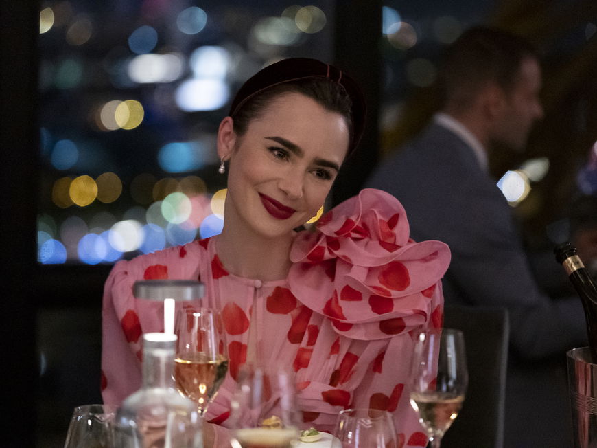 Emily in Paris in einem bunten Oberteil