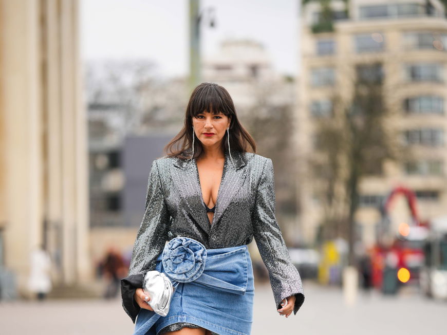 Gili Biegun trägt Blazer in Silber kniehohe Stiefel und Jeansrock