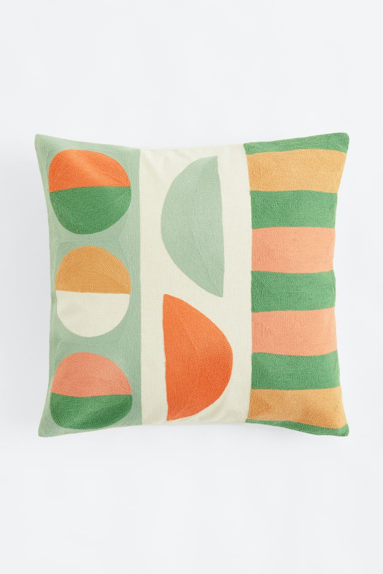 Bestickte Kissenhülle mit grünem, orangenen und beigen Muster von H&M, ca. 25 Euro