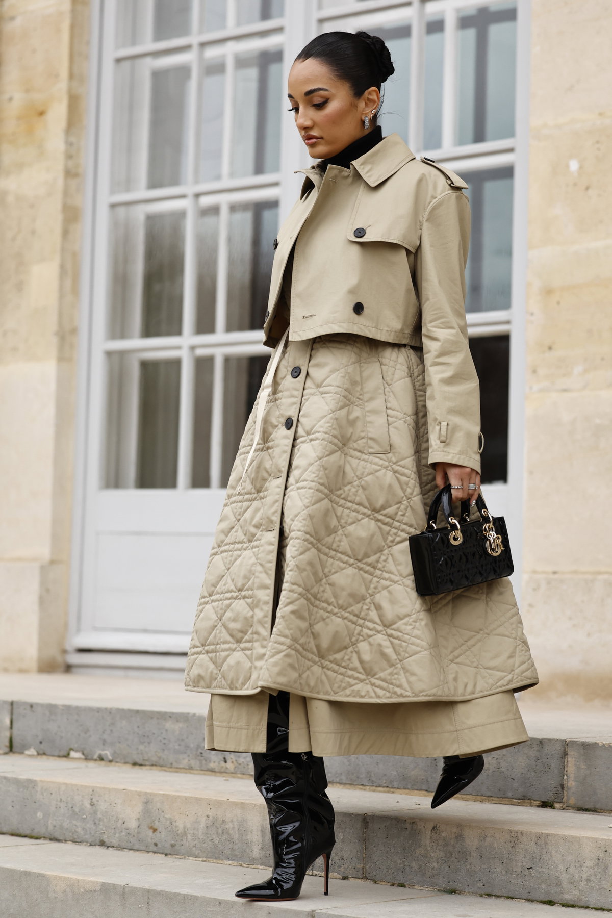 Frau trägt Stepprock beige mit Trenchcoat und schwarzen Heels