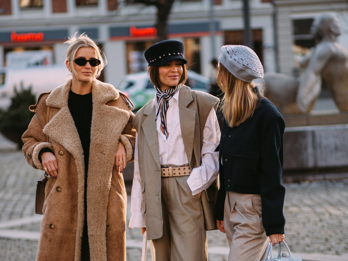 Drei stylische Frauen unterhalten sich auf der Fashion Week