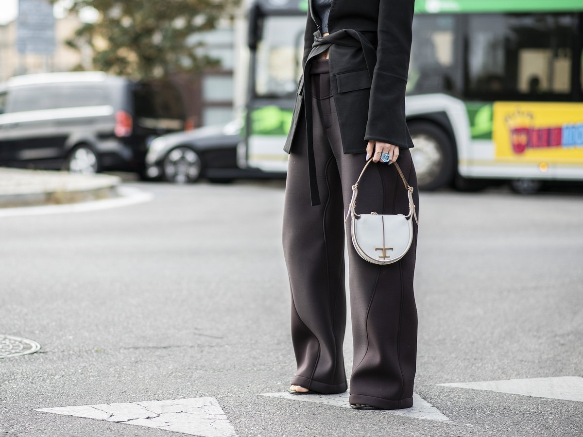 Frau mit Hosenanzug und weißer Tasche