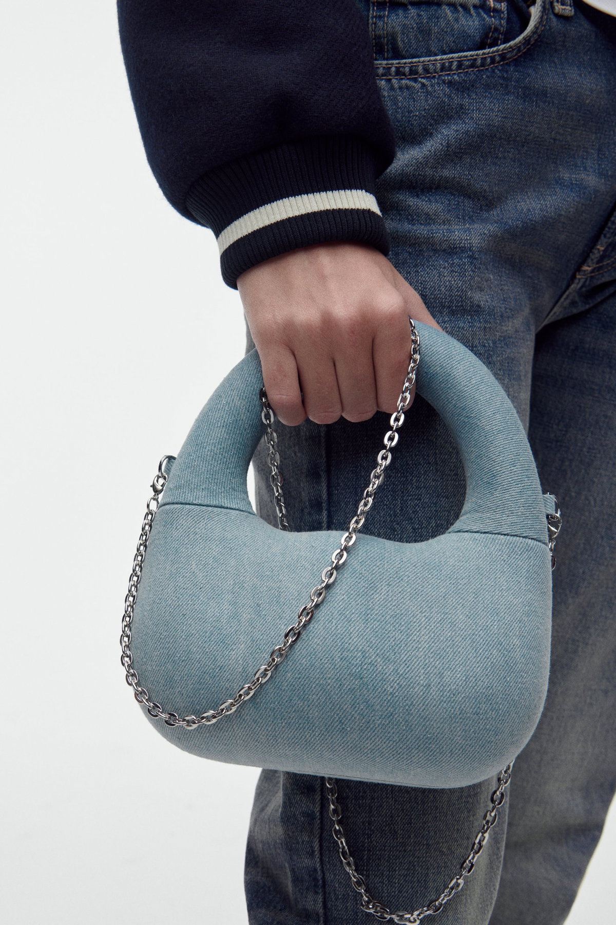 Feste Handtasche mit Henkel und Kettengliedern aus Denim-Material in hellem Blau, ca. 46 Euro