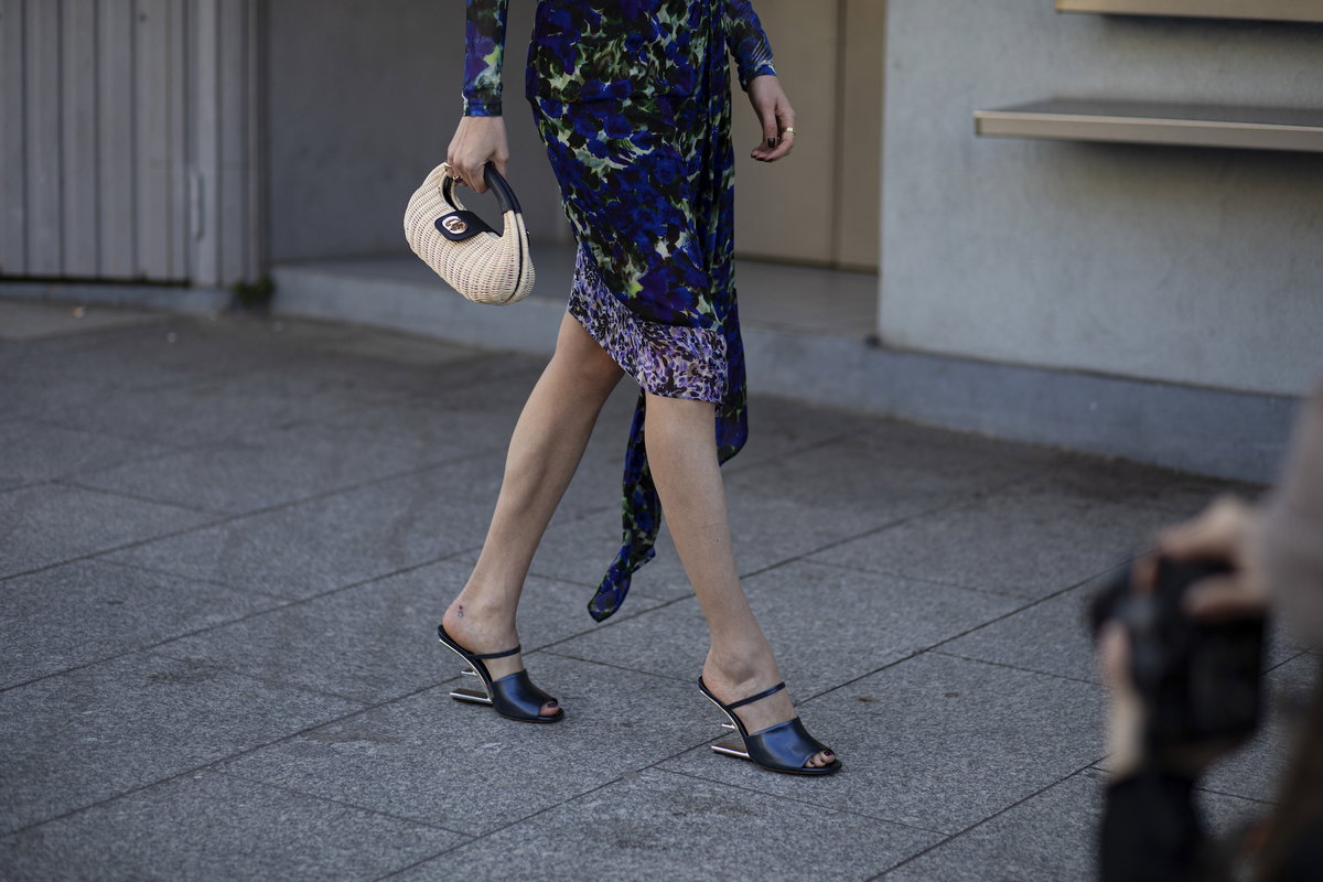 Frau im Sommerkleid und Korb-Handtasche