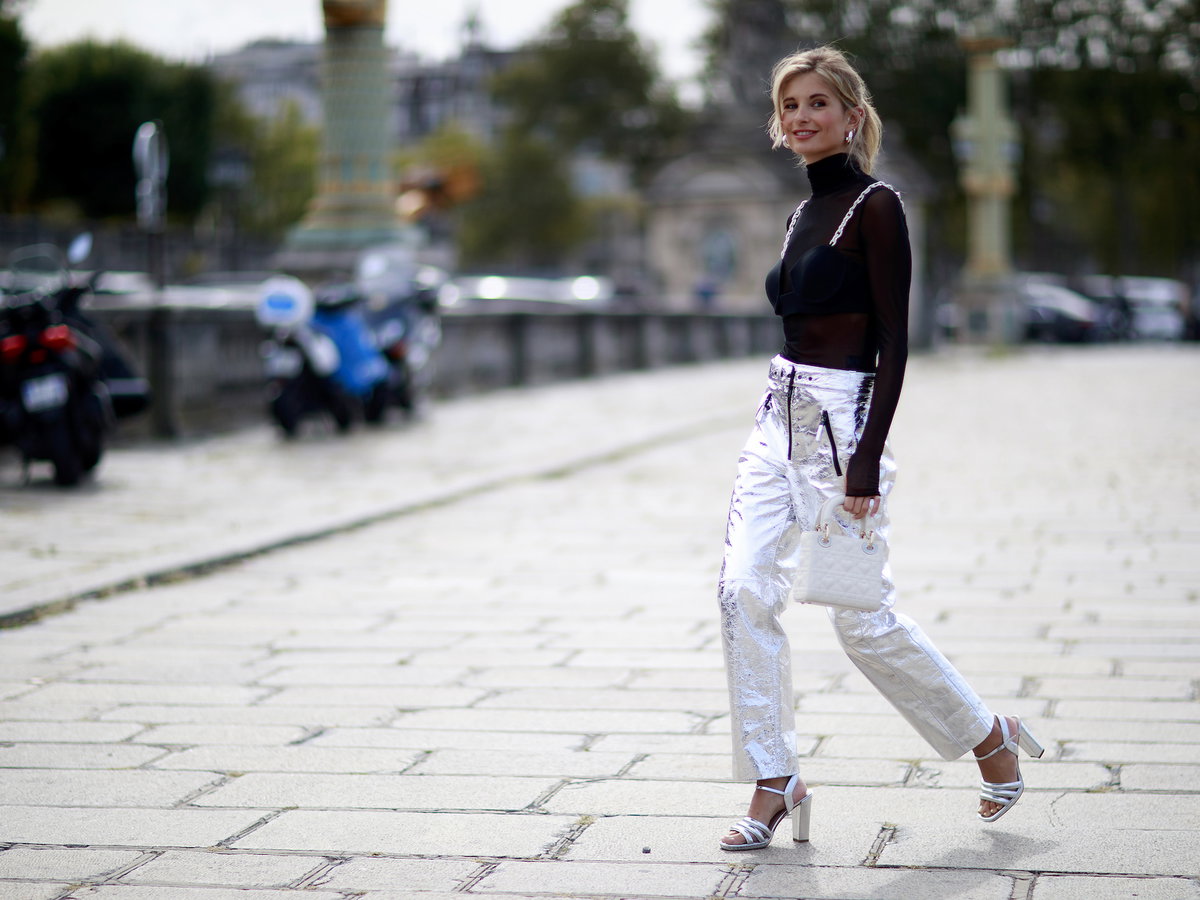 Xenia Adonts trägt eine silberne Hose mit schwarzen Oberteil