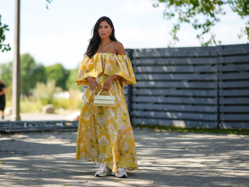 Frau im gelben floralen Maxi-Kleid