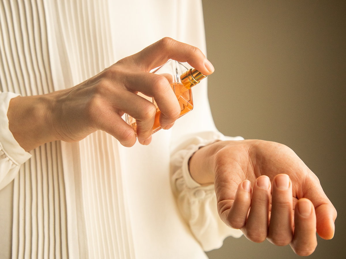Frau trägt Parfum auf