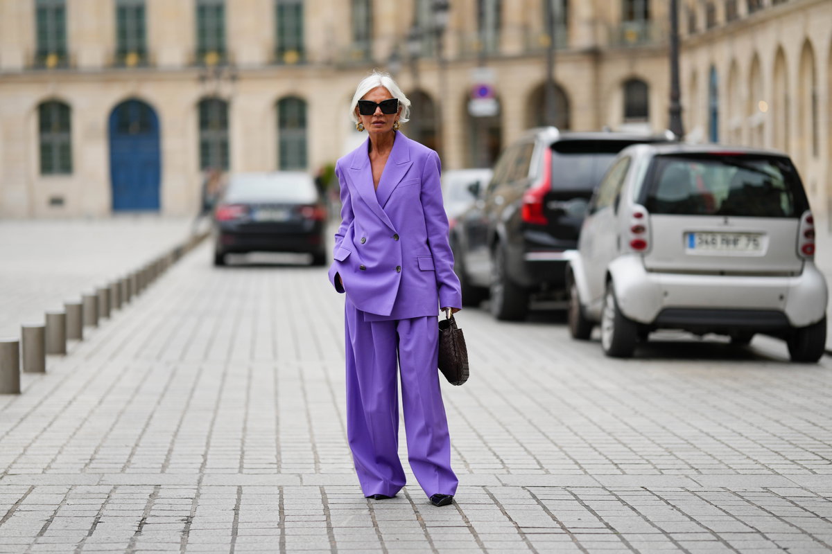 Frau mit violettem Hosenanzug und grauen Haaren
