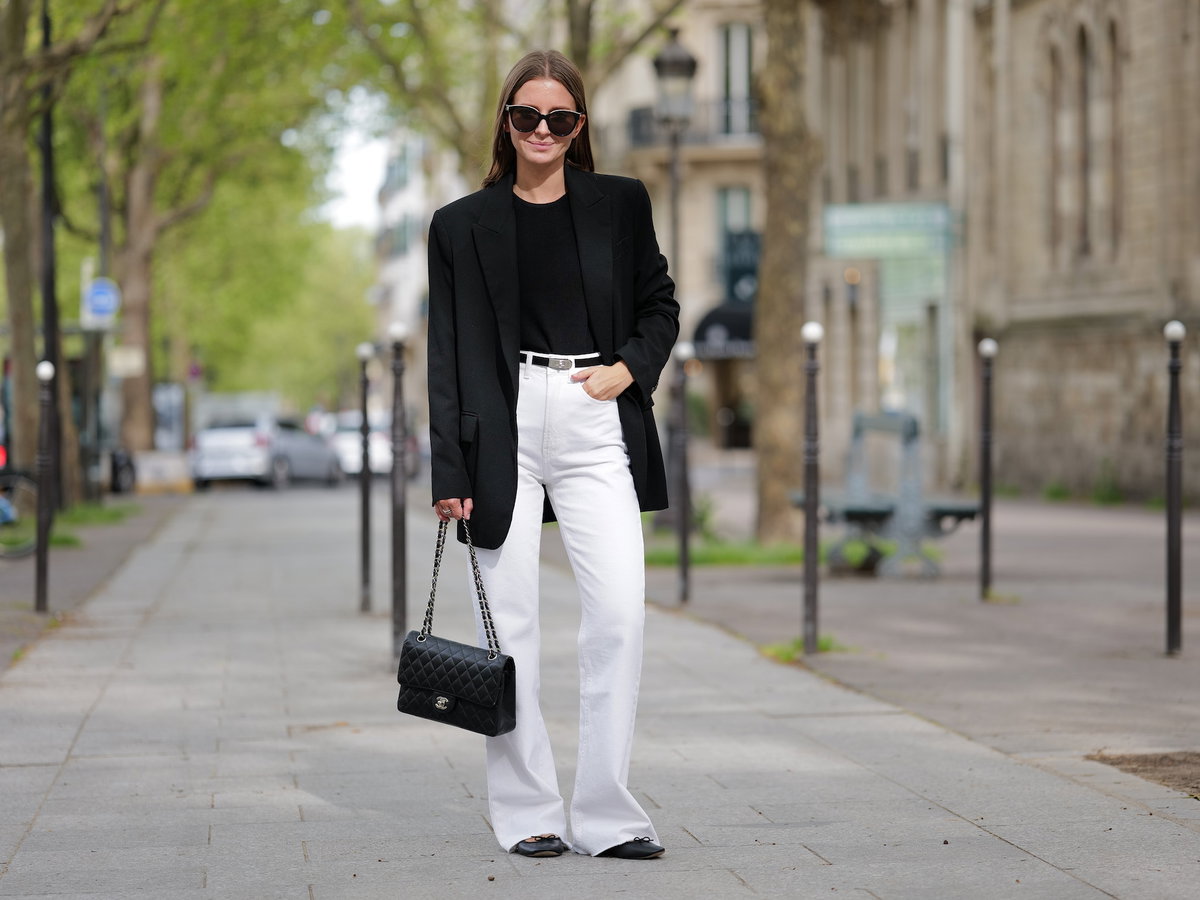Eine Frau trägt einen Blazer und eine Jeans