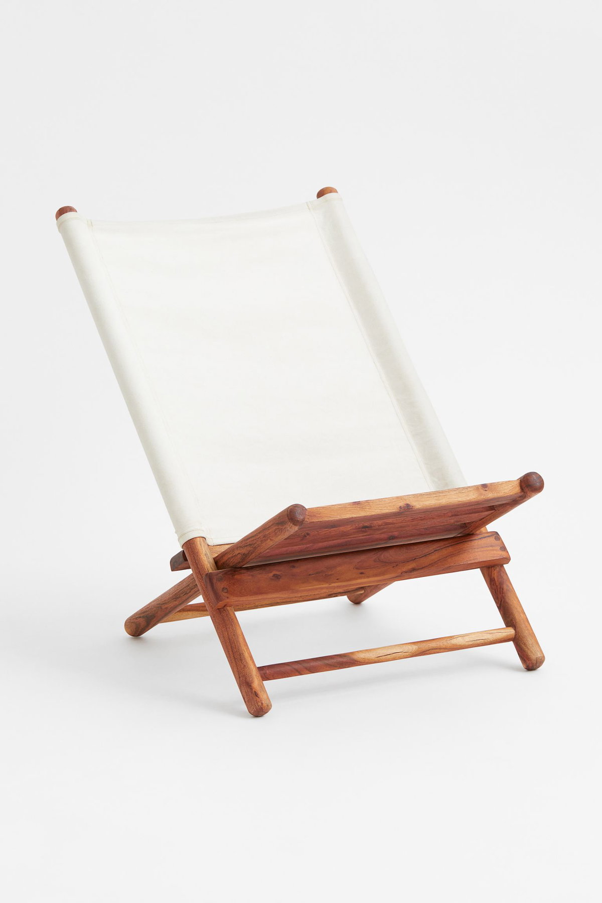 Klappbarer Loungestuhl aus Akazienholz mit weißem Baumwollstoff perfekt für den Außenbereich von H&M Home, ca. 169 Euro