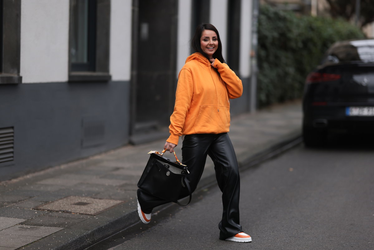 Frau mit schwarzer Hose und Hoodie
