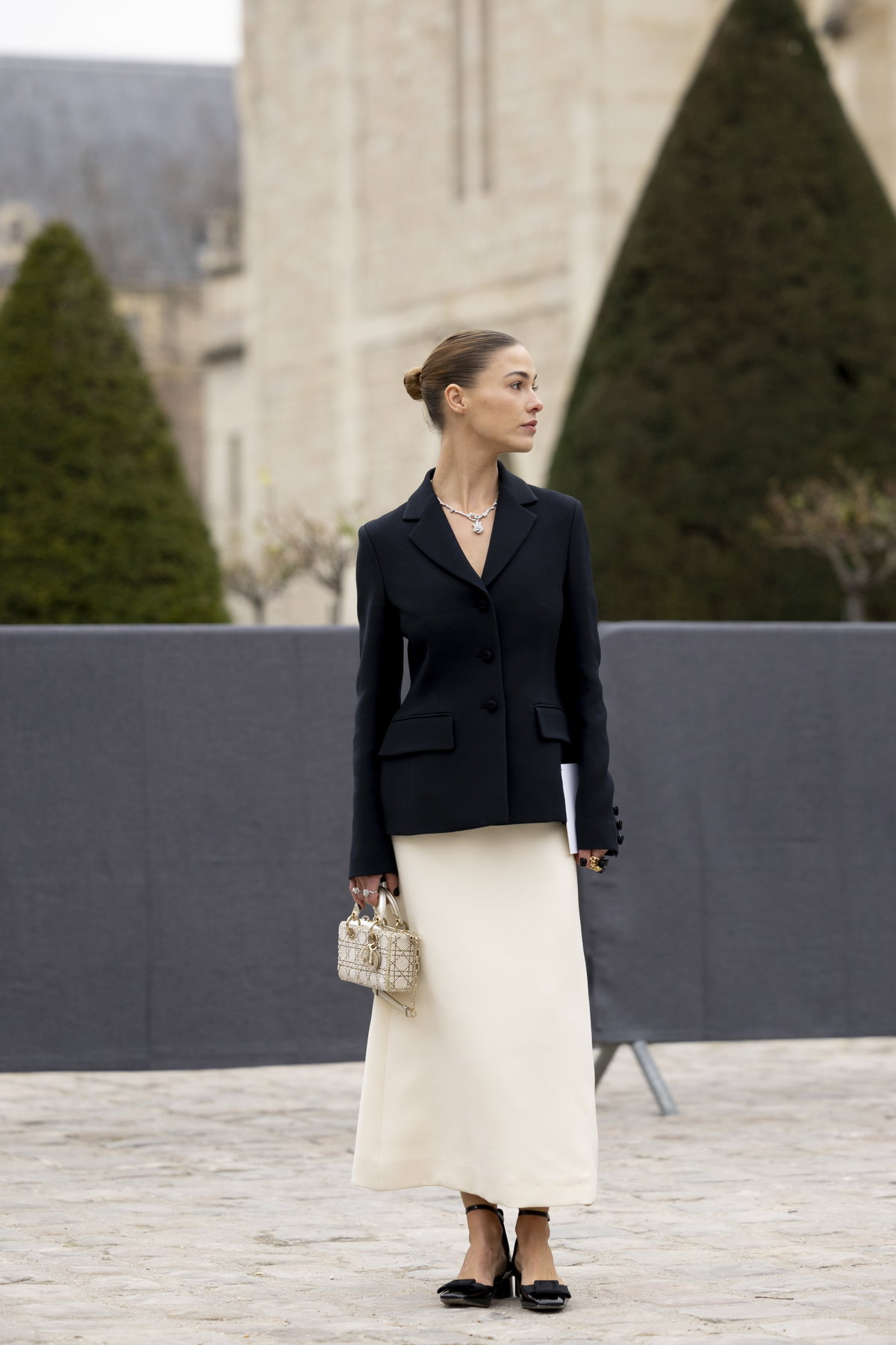 Eine Frau trägt einen langen weißen Rock und einen schwarzen Blazer