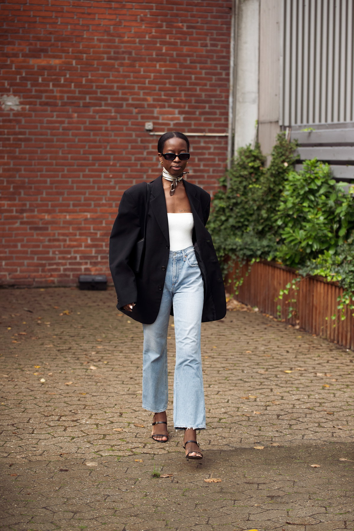 Eine Frau trägt eine blaue Jeans und einen schwarzen Blazer