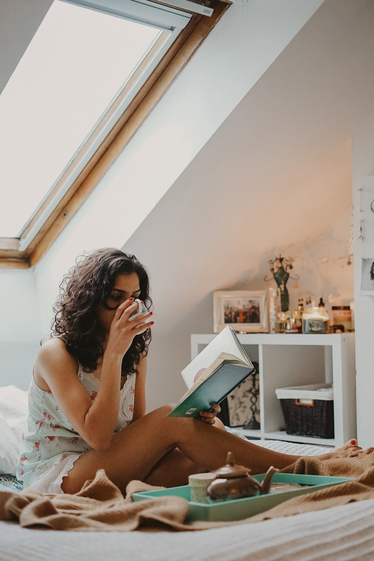Frau liest Buch mit Kaffee in der Hand
