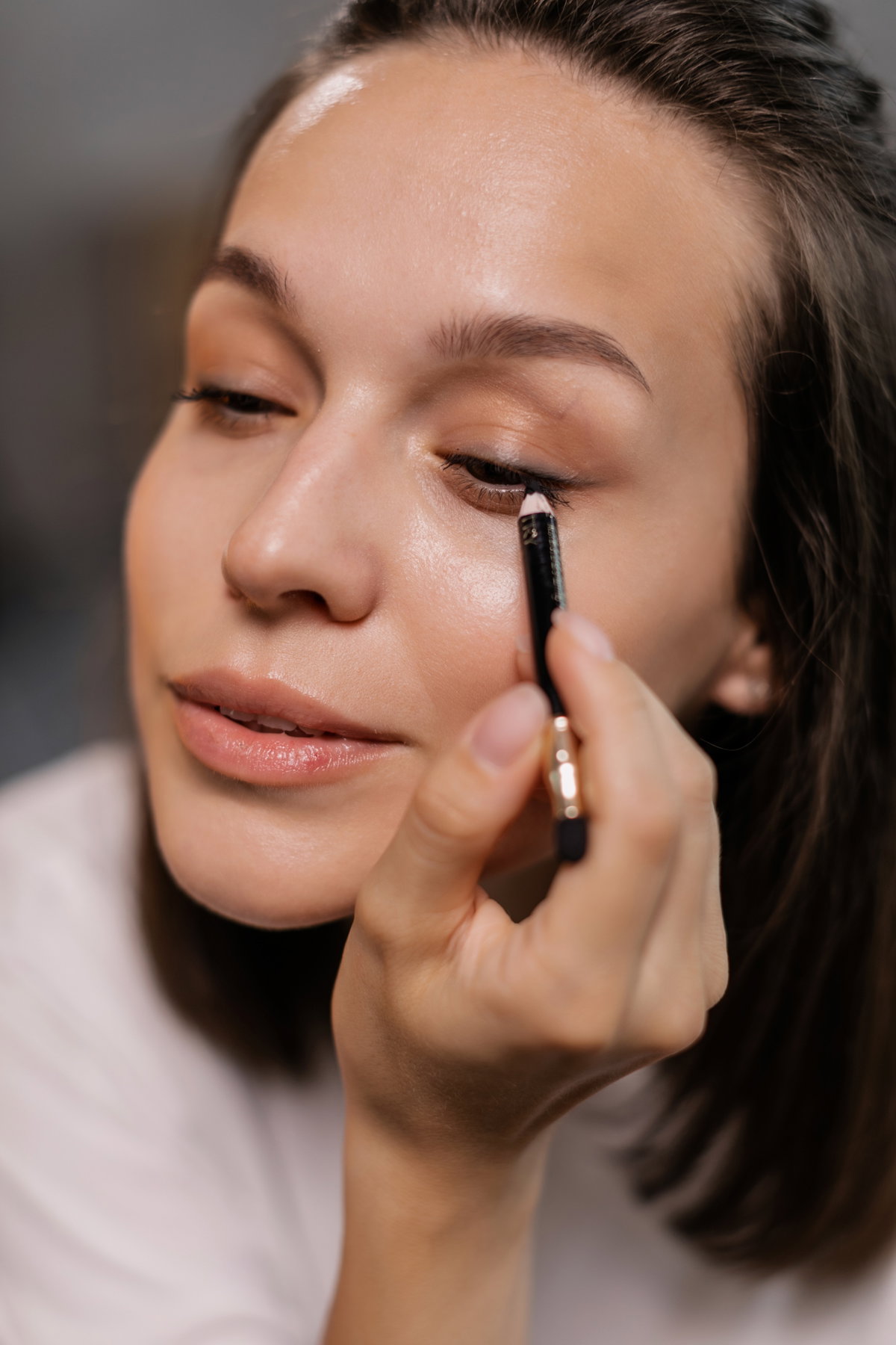 Frau trägt schwarzen Eyeliner auf