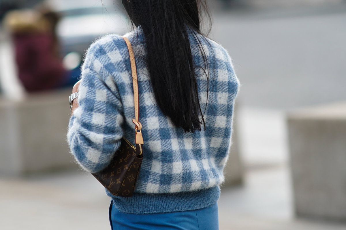 Eine Frau trägt eine Louis Vuitton Monogram Pochette Tasche