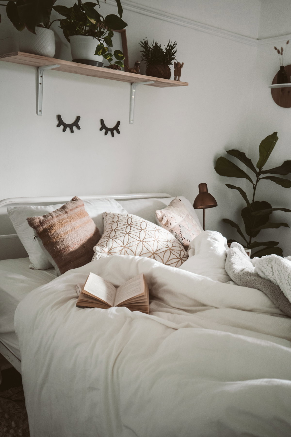 Bett mit weißer Bettwäsche im Schlafzimmer