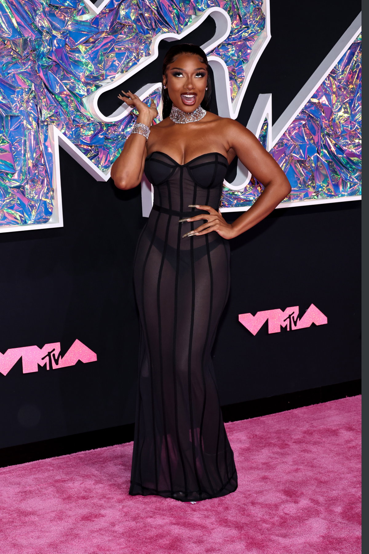 Megan Thee Stallion punktet auf den VMAs in einem transparenten Kleid mit Korsage, das dank der funkelnden Accessoires sehr glamourös wirkt.