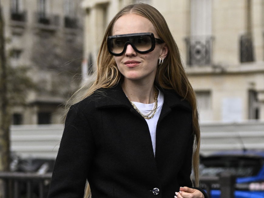 Alexandra Carl trägt schwarzen Cardigan und blaue Jeans auf der Paris Fashion Week im Oktober Streetstyle