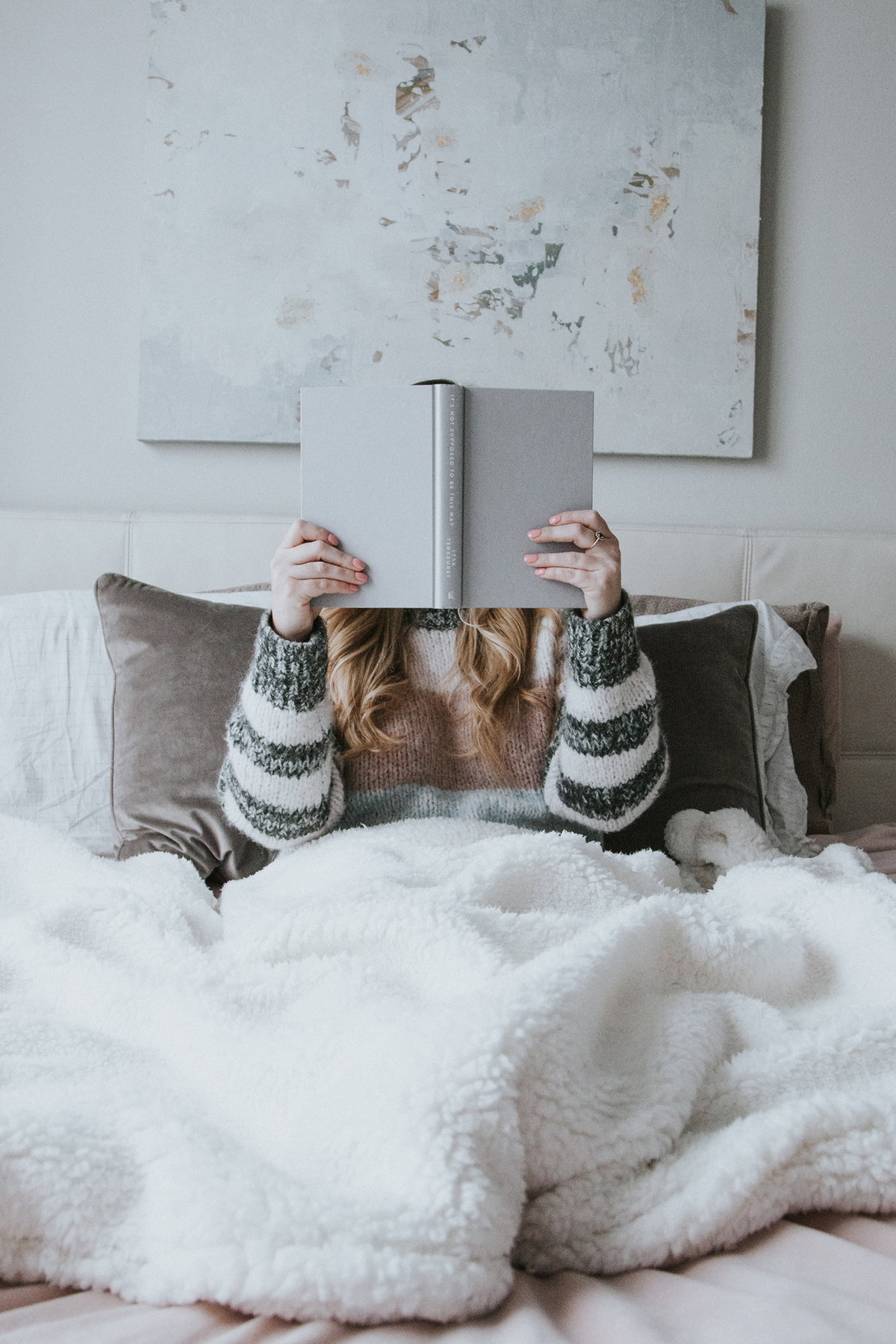 Frau liest Buch im Bett
