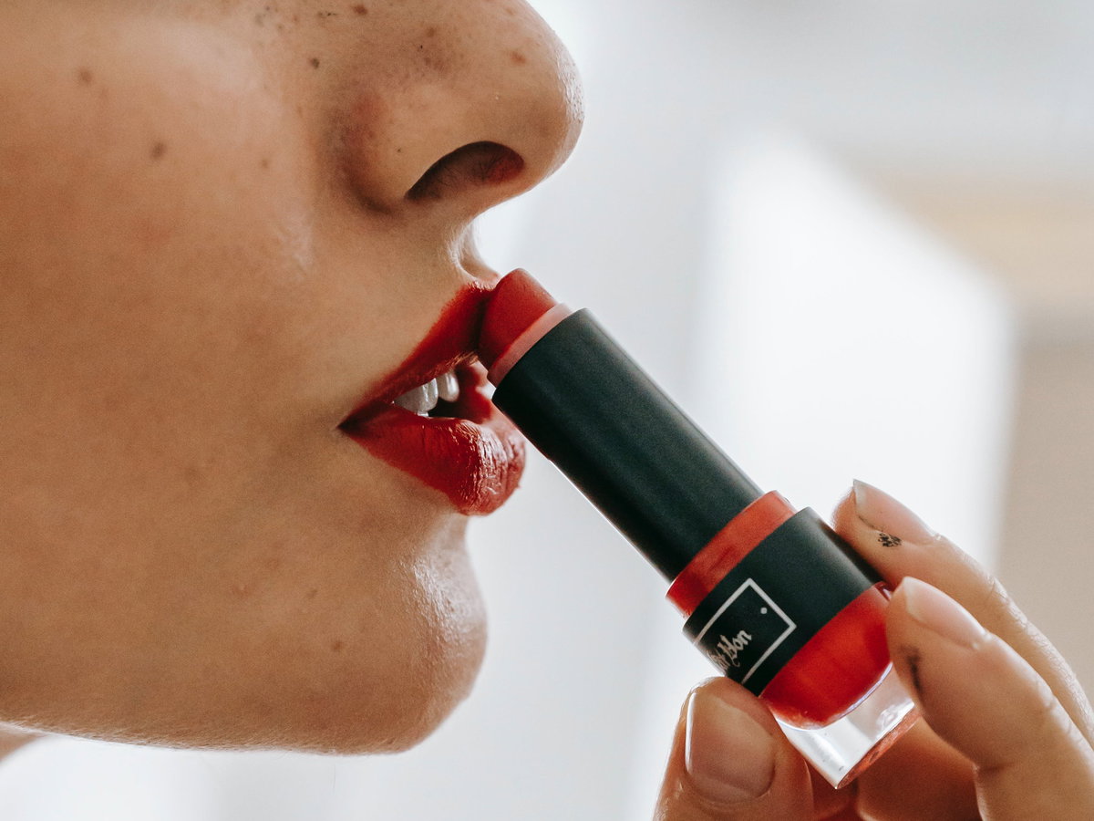 Frau trägt Lippenstift auf