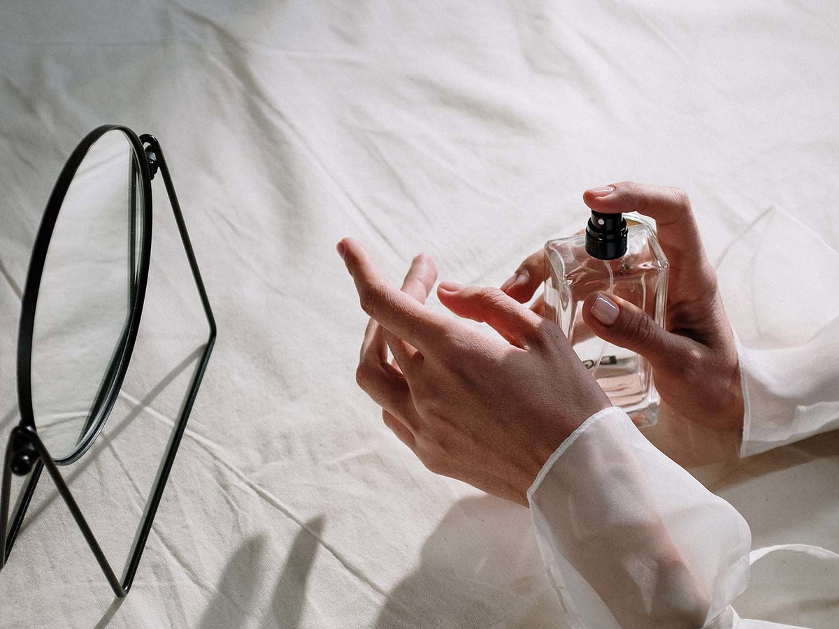 Frau trägt Parfum auf ihr Handgelenk auf