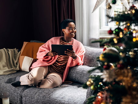 Frau hat Me Time und sitzt vor dem Weihnachtsbaum
