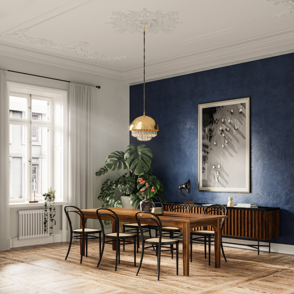 Stilvoll eingerichteter Raum mit großem Holztisch und goldener Deckenleuchte