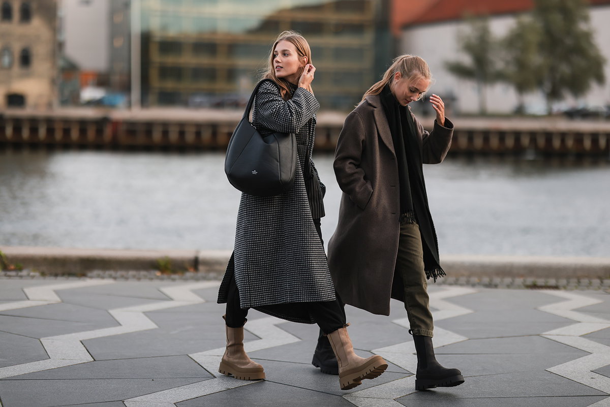 Zwei Frauen gehen mit herbstlichen Outfits spazieren