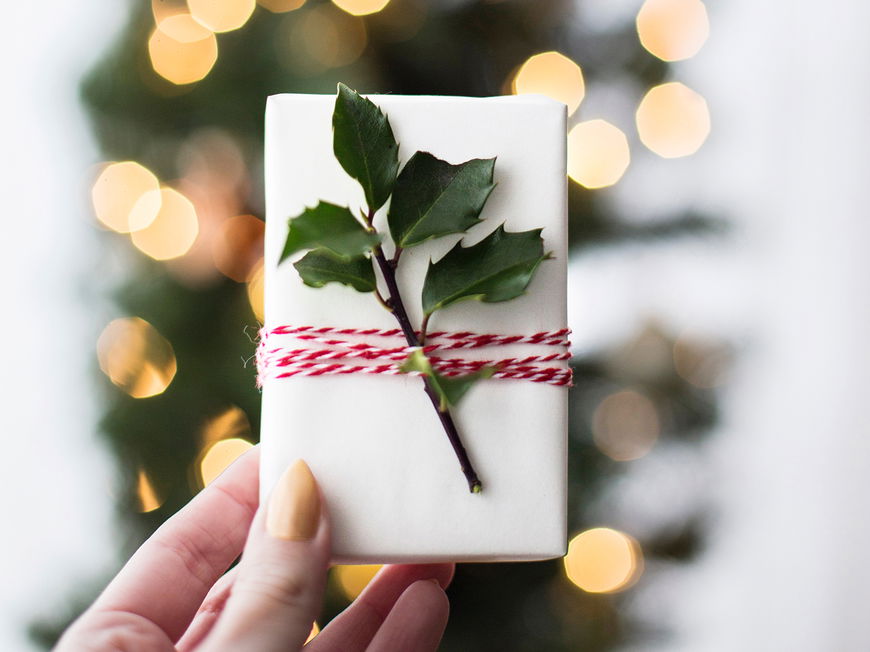 Frau hält Weihnachtsgeschenk in der Hand