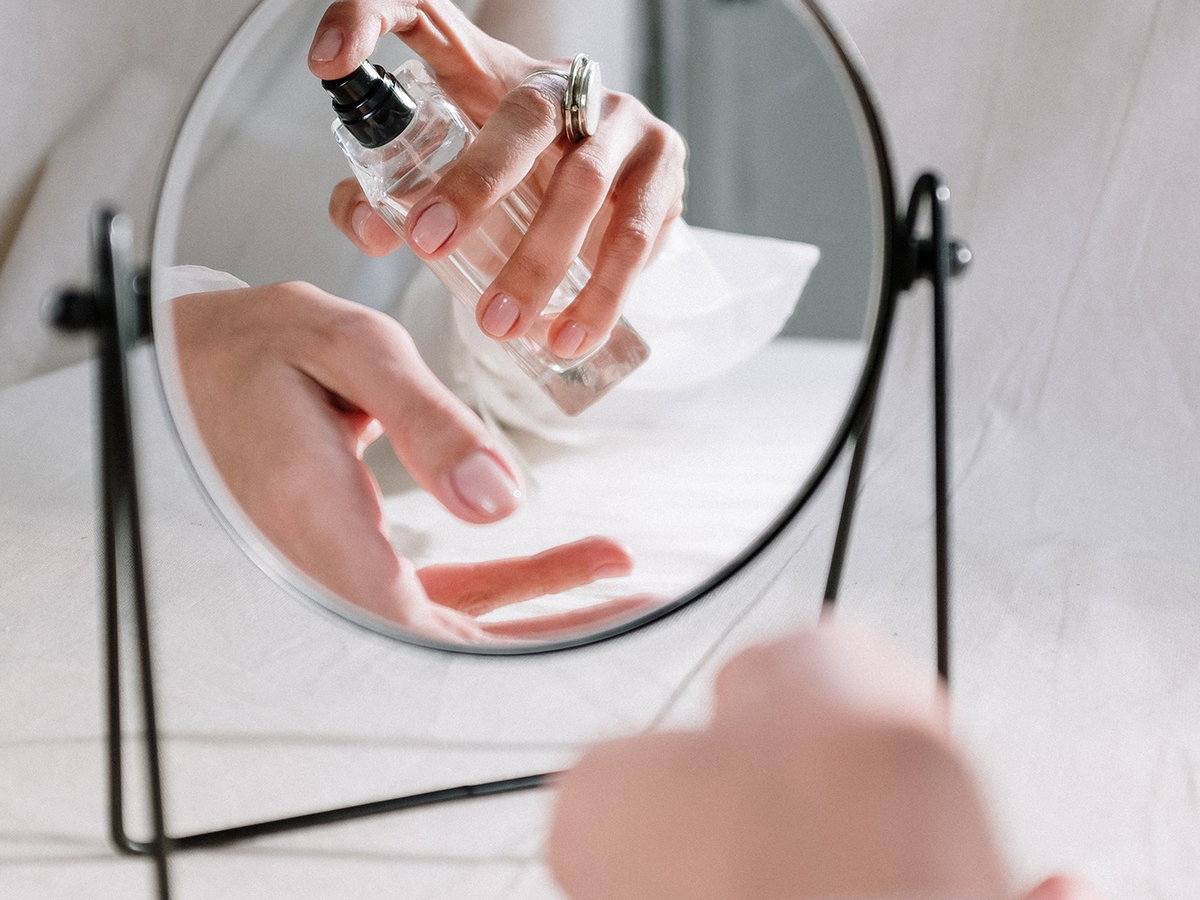 Frau trägt Parfum aufs Handgelenk auf