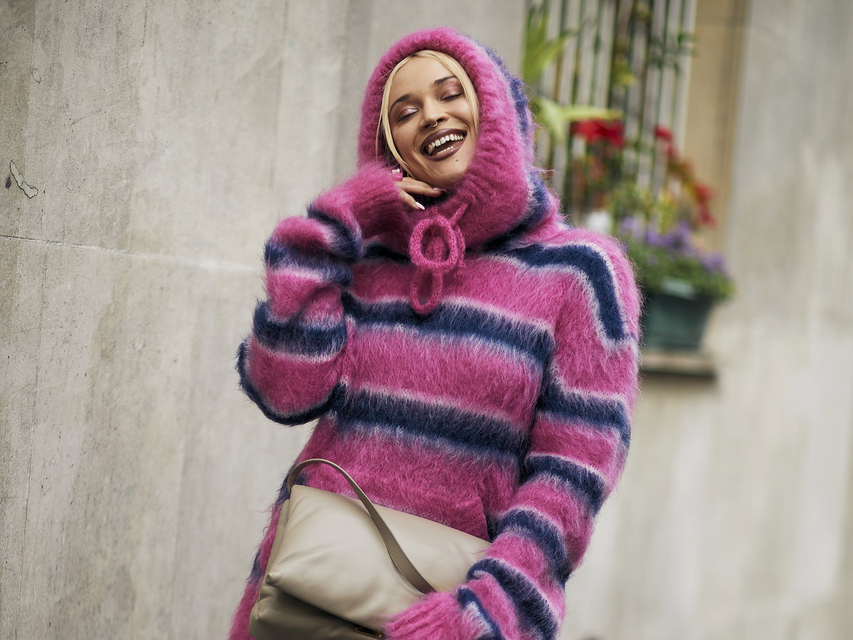 Frau auf Paris Fashion Week im Oversize Strickpullover und Jeansshorts