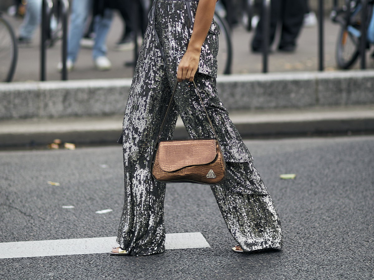 Frau trägt auf Paris Fashion Week schimmernde Hose in Silber
