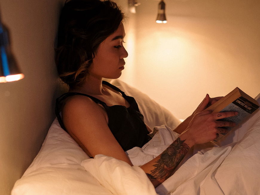 Frau liest ein Buch im Bett