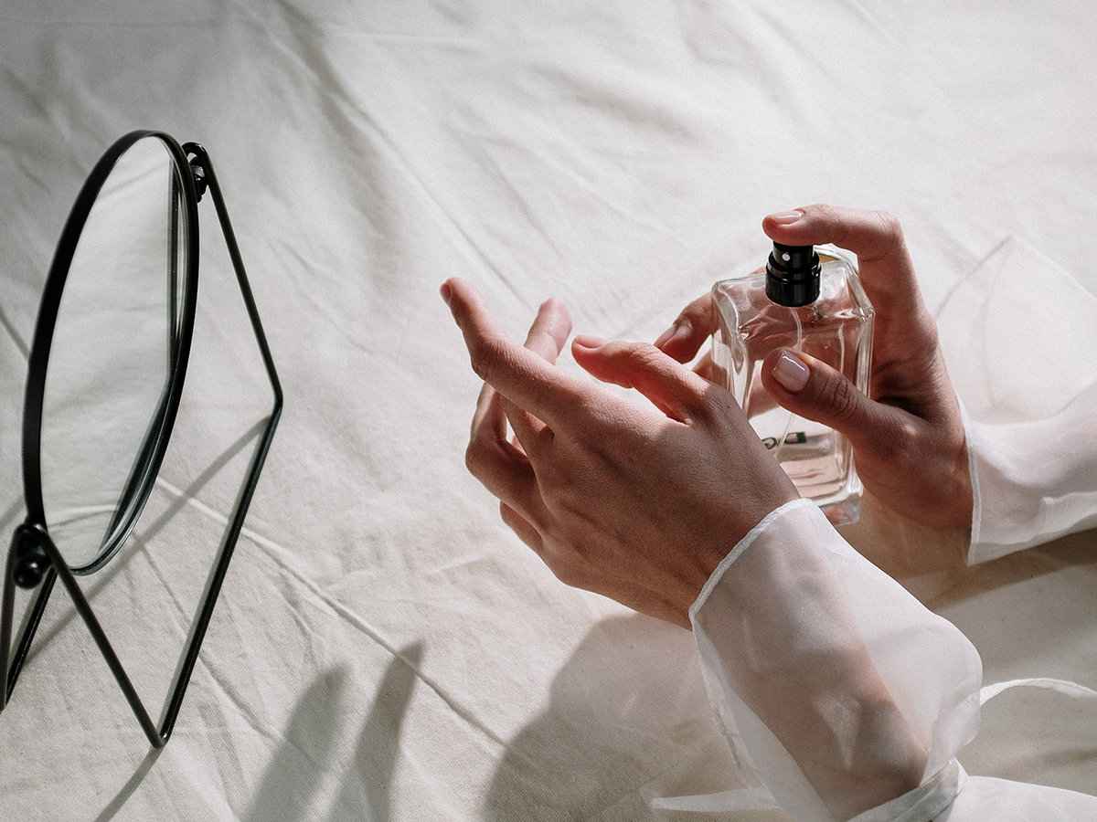 Frau trägt Parfum auf Handgelenk auf