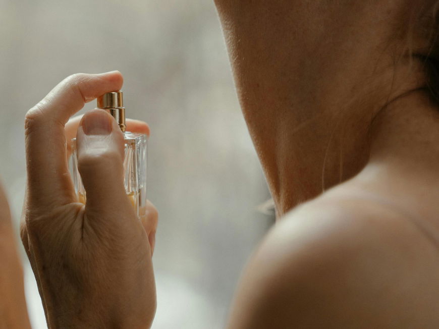 Frau trägt Parfum auf