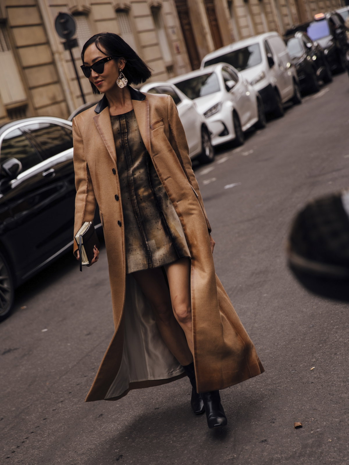 Frau trägt auf Paris Fashion Week Minikleid mit braunem Ledermantel und Boots