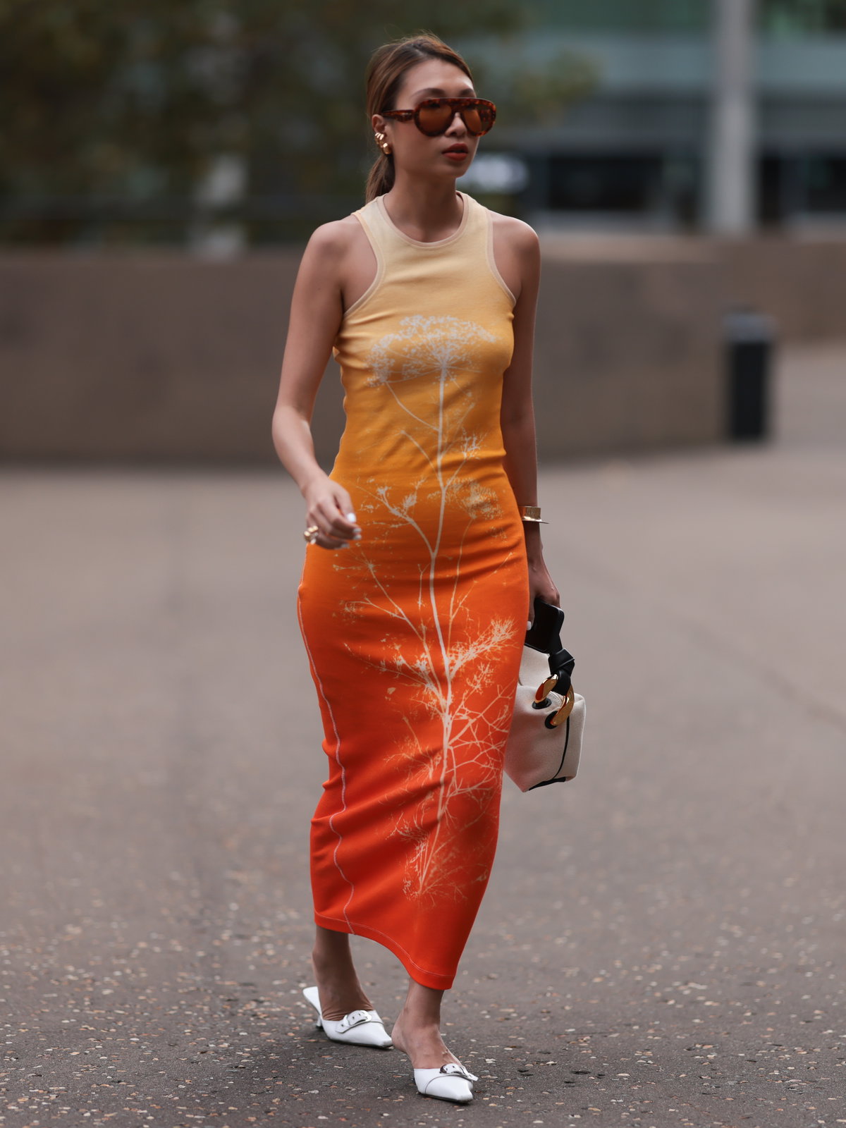 Frau trägt Mules zu orangenem Kleid