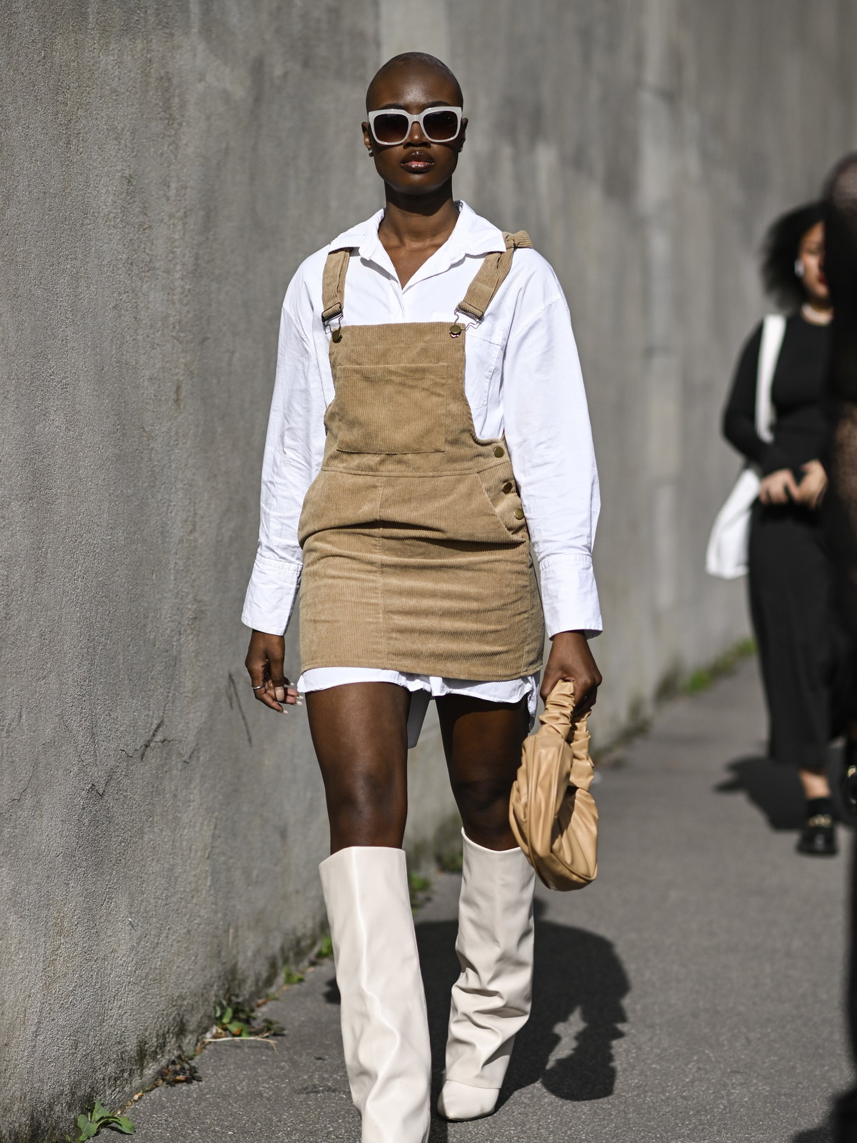 Stylische Frau trägt Minikleid aus Kord und in Latzoptik Givenchy Boots und Tasche