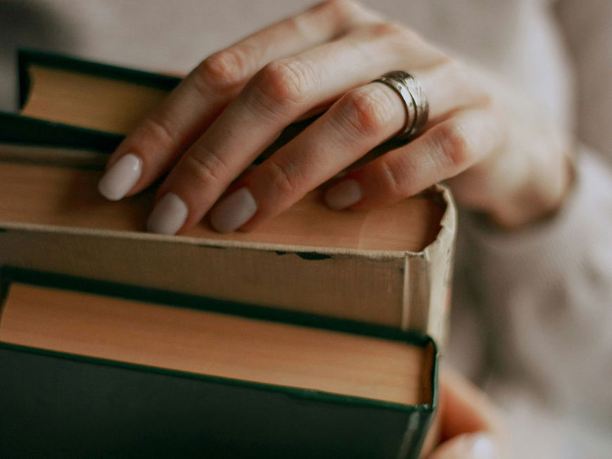 Frau hält drei Bücher in den Händen