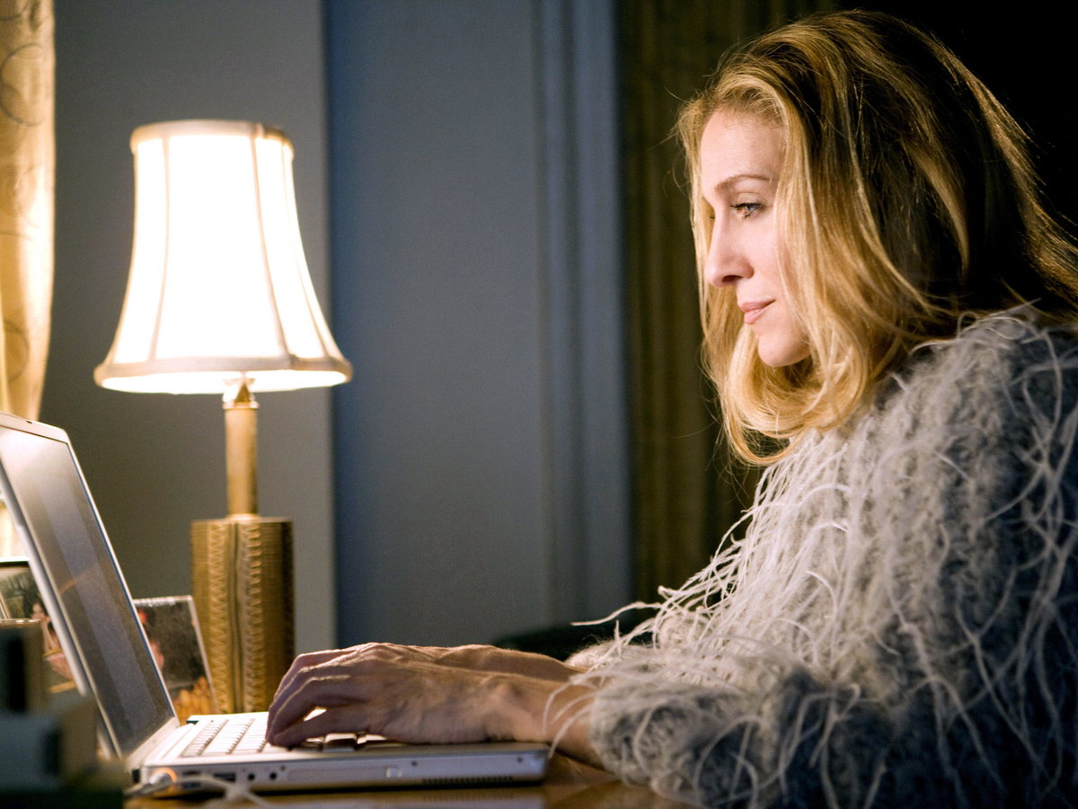 Carrie Bradshaw sitzt vor Laptop
