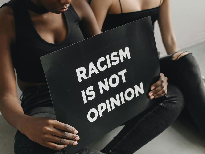 Zwei Frauen mit Schild "Racism is not opinion"